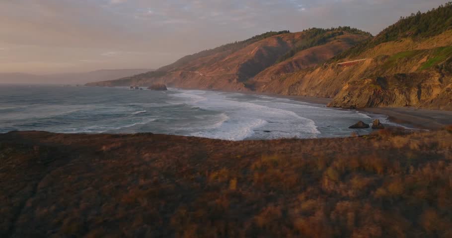 Serene view of California coast at dusk with rolling waves and golden light