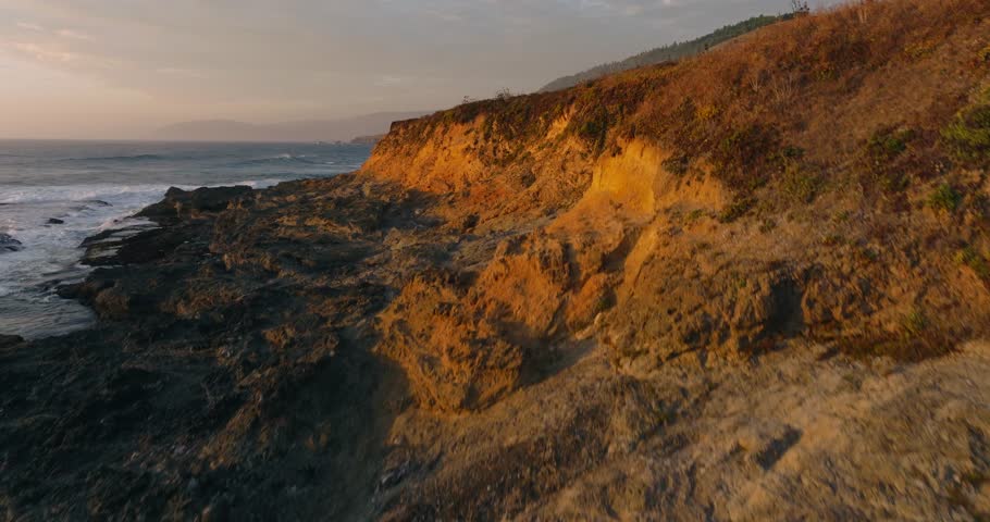 California coast at sunset, rugged cliffs, and ocean waves