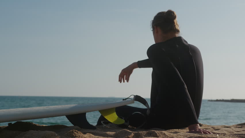 Surfer man walking to the beach at sunset preparing for surfing training and search for waves in Barcelona, spain, water, ocean exercise in sea with board, athletic male holiday or travel in vacation.
