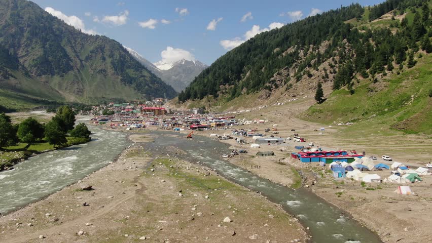 Discover remote beauty camping by the river in a mountain valley, ideal for adventure travel and outdoor lifestyle marketing campaigns