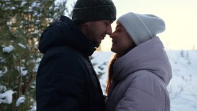 Romantic couple in warm outfit embraces in sunset winter forest. Young boyfriend and girlfriend hug affectionate on date in snowy woods - Powered by Shutterstock - Get 15% off with code: PIKWIZARD15
