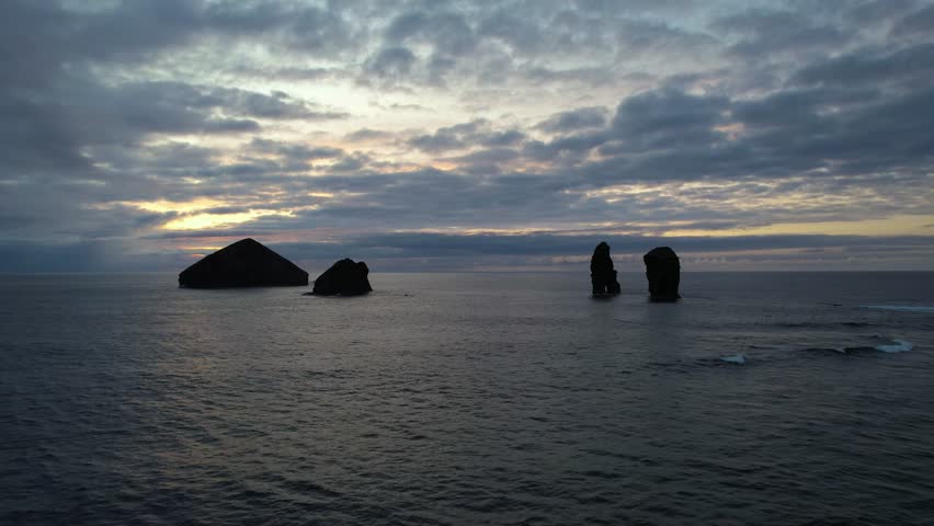  Volcanic sea stacks rise from ocean at sunset