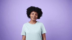 Young african american woman blowing kisses in slow motion on purple background - Powered by Shutterstock - Get 15% off with code: PIKWIZARD15