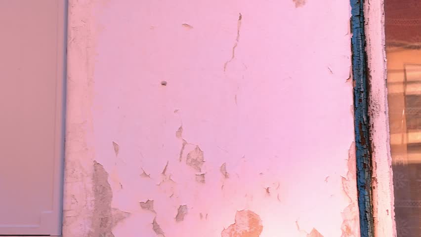 View of the shabby facade of an old house. View of the old facade of the house, its windows and gates. Concept of estate agencies, reconstruction in the building sector.