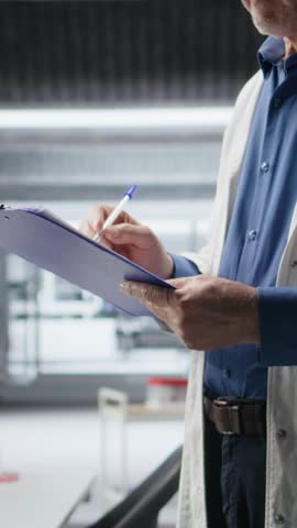 Vertical Video Close up of papers used to check on chemical data during lab work, medical discovery in laboratory. Modern equipment for bioscience and molecular research to drive pharmaceutical