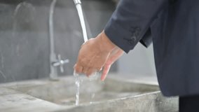 Close-up of male hands being washed under running tap water in a contemporary restroom - Powered by Shutterstock - Get 15% off with code: PIKWIZARD15
