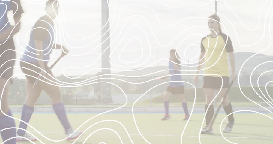 field hockey attacker dribbling past defender, executing low shot and sparking scramble at goal. Athletes, competition, sport, action, teamwork, outdoor, dynamic