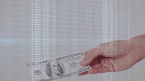 Hand entering frame holding hundred-dollar bill, overlay fading and shifting to show market values. Financial, data, digital, analysis, investment, technology, economy - Powered by Shutterstock - Get 15% off with code: PIKWIZARD15