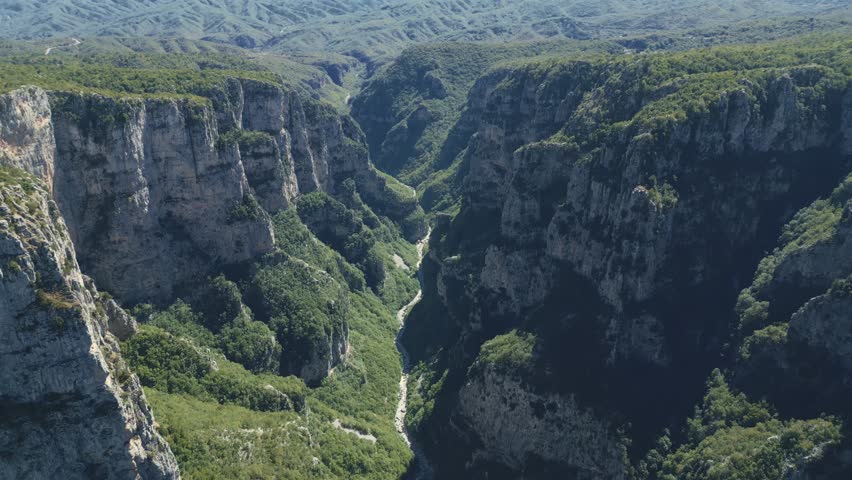Drone footage of Vikos Gorge in Epirus, Greece, showing steep cliffs, lush greenery, and dramatic mountain landscape. Perfect for travel, nature, and documentary projects.