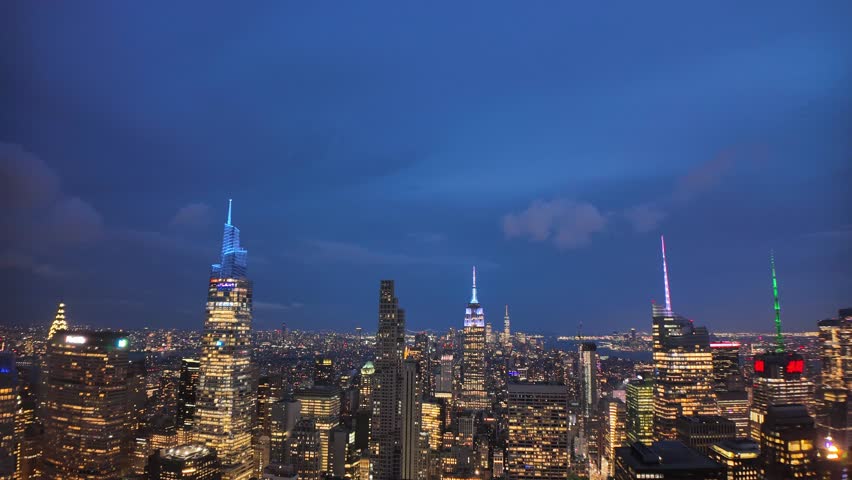 Timelapse of New York City skyline illuminated at night with glowing lights and skyscrapers