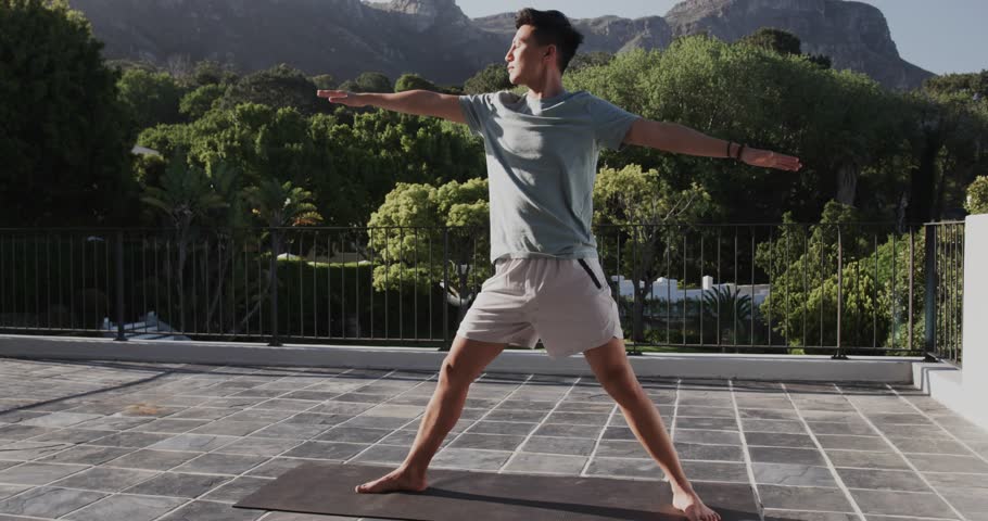 Yoga instructor doing side stretch on terrace spawning AR code panels as dog passing between legs. Fitness, wellness, meditation, outdoor, technology, nature, relaxation