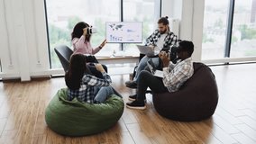 Group of diverse adults using virtual reality headsets and laptops in modern office setting. Individuals of various backgrounds collaborating in technology-driven workspace fostering creativity - Powered by Shutterstock - Get 15% off with code: PIKWIZARD15