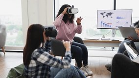 Women interacting with virtual reality technology wearing VR glasses in office setting. Exploring immersive digital experience, modern technology engaging workplace activities. - Powered by Shutterstock - Get 15% off with code: PIKWIZARD15
