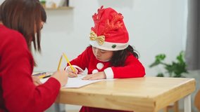Young child wearing festive hat engaged in drawing while mother assists at holiday celebration, capturing family bonding moments and creativity - Powered by Shutterstock - Get 15% off with code: PIKWIZARD15