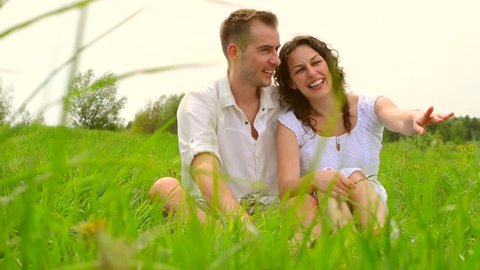 Happy Couple Relaxing Outdoor. Nature. Green Field. Dolly Slider Shot