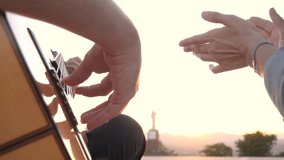 African American woman clapping in rhythm to a Spanish acoustic guitar as the guitarists hands strum the strings, silhouette and warm sunset lighting create an intimate outdoor performance scene - Powered by Shutterstock - Get 15% off with code: PIKWIZARD15