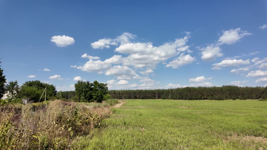 beautiful green meadow under a cloudy sky, rural agricultural landscape, time lapse scene. ukrainian landscape. Ukraine. high quality top footage.