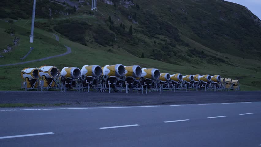 Aerial view of idle snow canons lined up along the alpine slope in Lech Zürs during late summer.