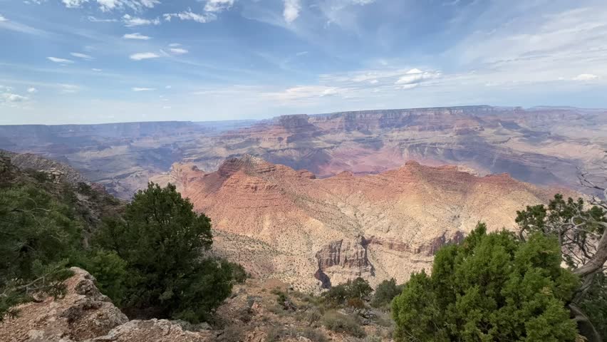 A mesmerizing time-lapse of clouds gracefully drifting over the vast expanse of The Grand Canyon, capturing the dramatic play of light and shadow across the ancient rock formations.  - Powered by Shutterstock - Get 15% off with code: PIKWIZARD15