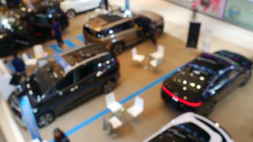 Time Lapse Blurred Car Exhibition in Shopping Mall - Defocused Auto Show Display with Bokeh Effect in Modern Showroom