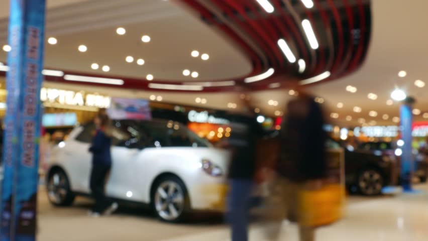 Time Lapse Blurred Car Exhibition in Shopping Mall - Defocused Auto Show Display with Bokeh Effect in Modern Showroom