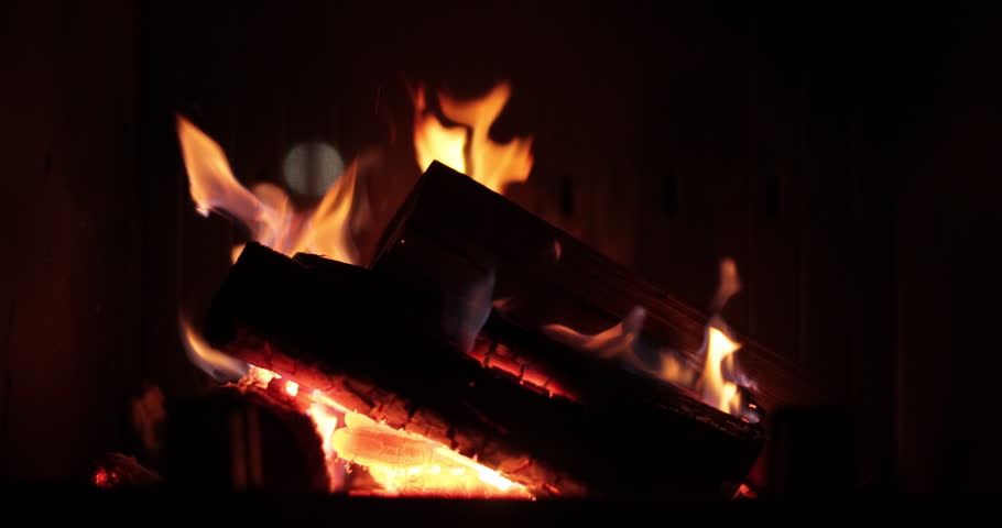 Home fireplace with burning wood, blazing fire creates a warm and cozy atmosphere. Scene is cozy and warm.