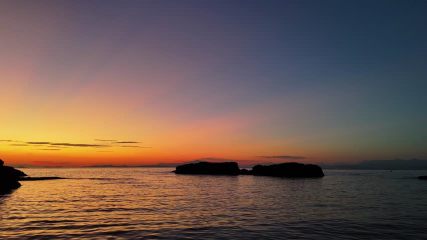 Dramatic sunset sky above Neck Point Park, Nanaimo. Warm light glows across the horizon and rocky shoreline