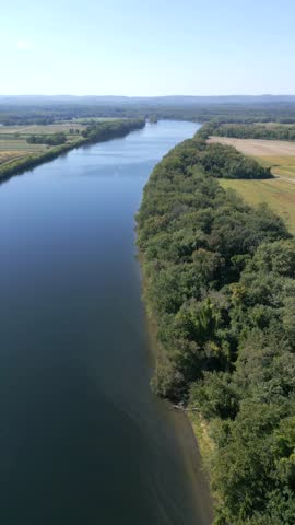 Vertical drone fly over Connecticut River side running through forested countryside, Hadley, Massachusetts, USA
