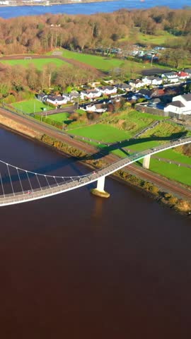 Travelling social ratio aerial of the Peace Bridge over the River Foyle in Derry, AKA Londonderry in Northern Ireland. Filmed in 1080x1920, 60FPS and with Rec709 color.