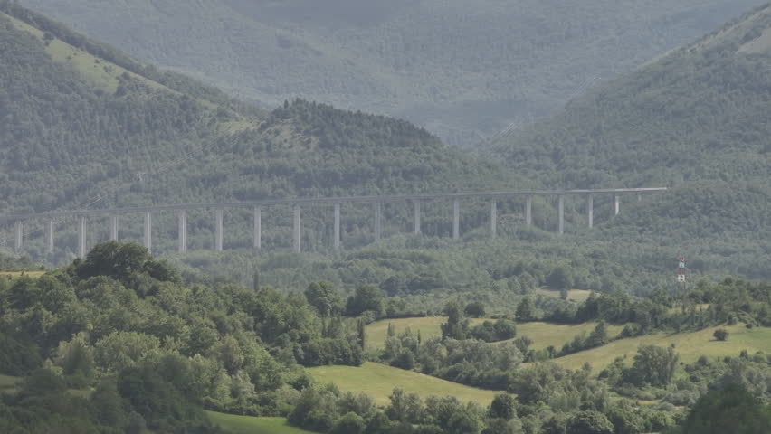 Modern Highway Viaduct Stretching Through Lush Mountains in Monteleone di Spoleto, Italy