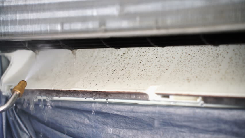 Cleaning mold inside a split air conditioner unit using high-pressure water spray to remove dirt and bacteria, ensuring better air quality and energy efficiency for home and office environments.