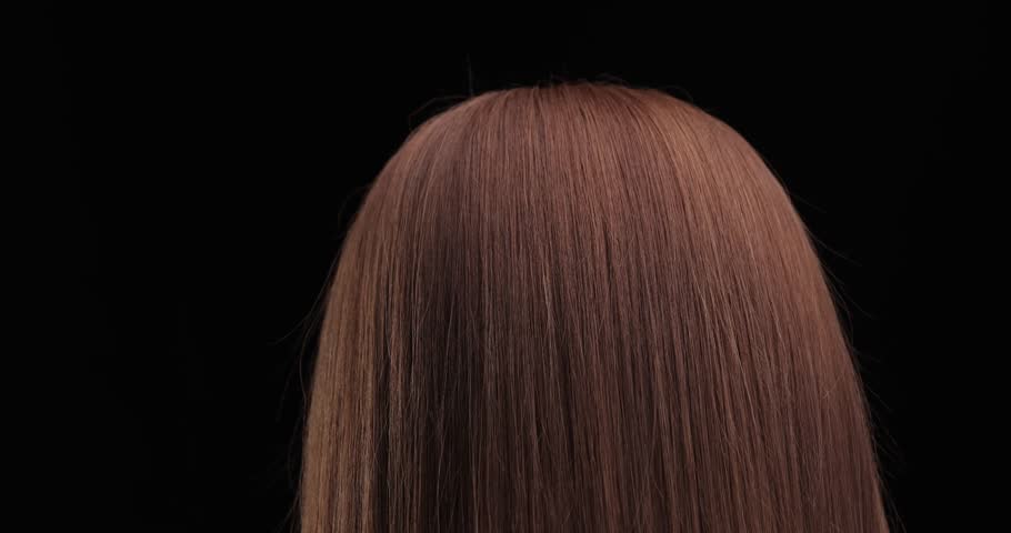 Smooth transition from long to blunt cut on shiny brown hair in salon.