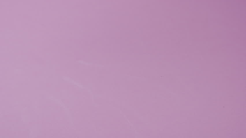 Slow motion video: white pills or capsules falling on a pink background. Concept of medicine, healthcare, supplements, and pharmaceutical treatment.