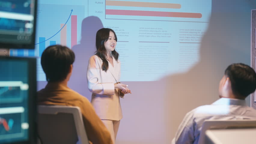 Asian business woman presentations slides chart graphs of work professionals collaborating on a late-night project meeting in a modern office. Brainstorming innovative ideas for a new business .