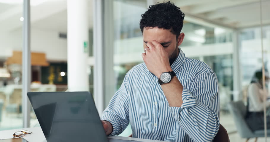 Business, man and headache with laptop in office for fatigue, article mistake and employee burnout. Stress, person and migraine with pc for glitch, submission error and brain fog from work pressure