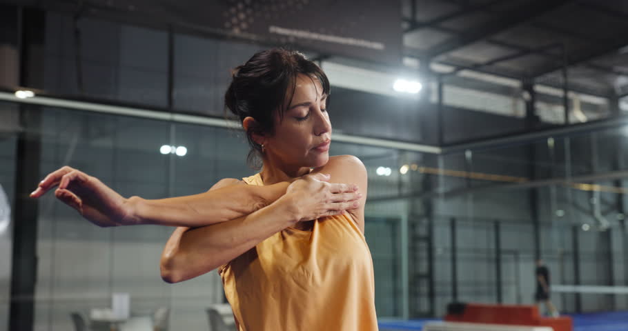 Athlete, woman and stretching on padel court for fitness, getting ready and prepare for challenge. Mature person, warm up and muscle for sports match, tournament event and technique for competition