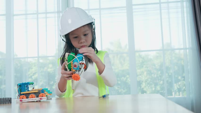 Young Engineers: multi ethnic Children engrossed in building and testing small robotics, showcasing curiosity, teamwork, and early STEM education. The focus robot and children hands-on engagement.