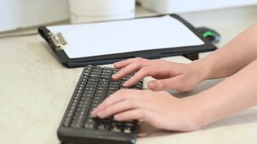 Close-up of a woman's hands typing on a computer keyboard next to a folder with notes on paper. Using technology at work. Office worker - Powered by Shutterstock - Get 15% off with code: PIKWIZARD15