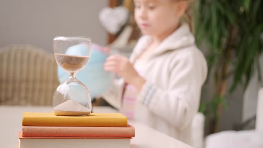 schoolgirl studies at home, girl Student learning geography with globe map, hourglass measuring time, global knowledge, back to school, Child homework, time management, Education and childhood - Powered by Shutterstock - Get 15% off with code: PIKWIZARD15