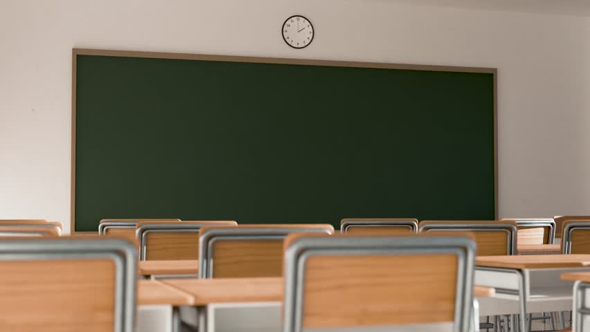 Empty classroom or lecture hall with a blank green chalkboard, wooden desks, and chairs. Concept of back to school, education, and learning