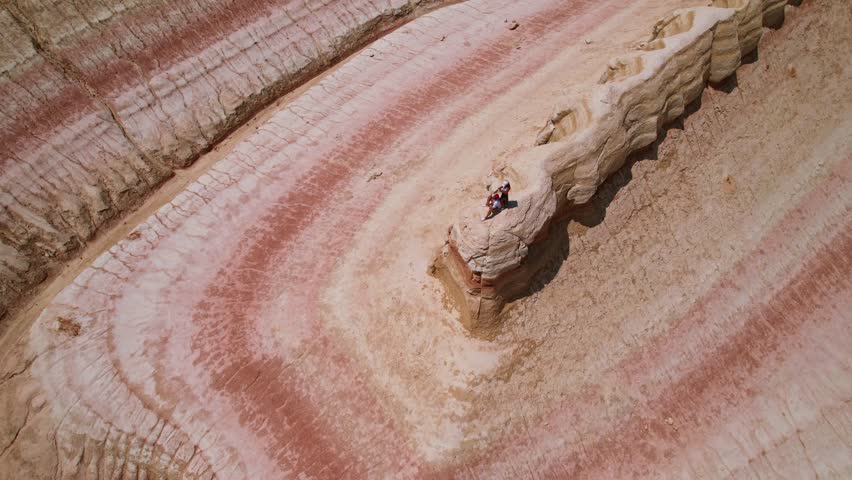 An aerial view captures the stunning striped rock formation in a desert environment