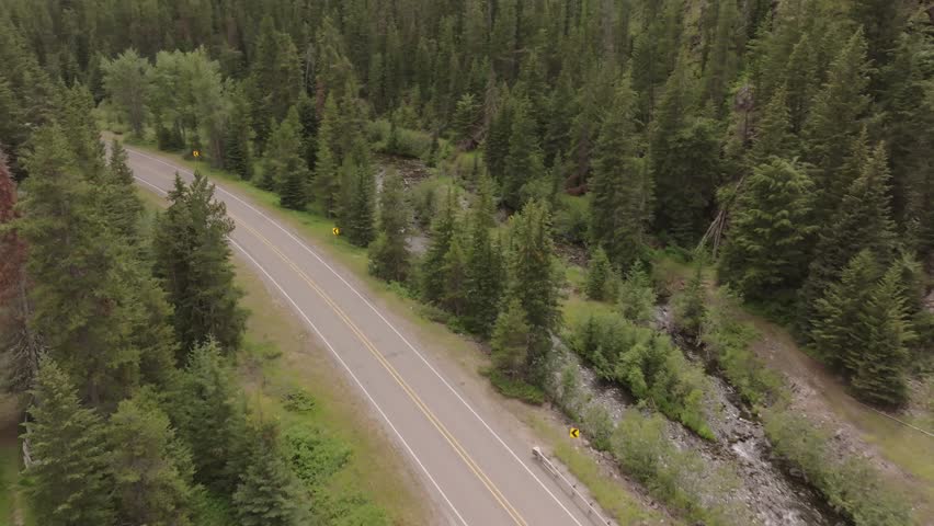 Drone shot of a car driving up a mountain in Canada