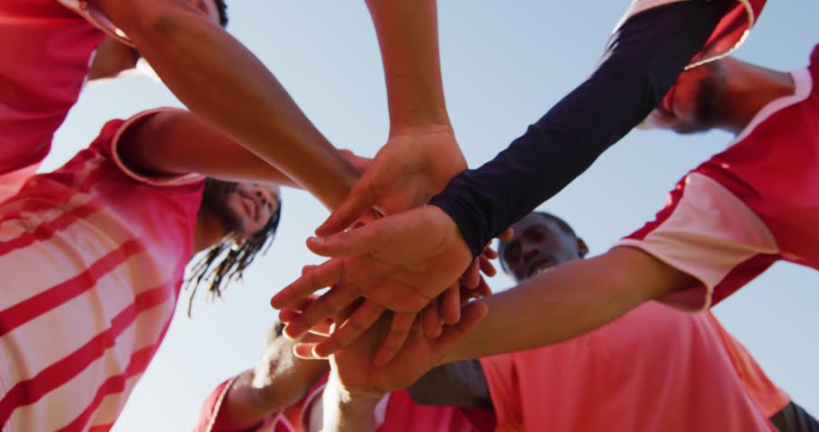 Sports team extending arms stacking hands initiating purple orange network overlay enhancing unity. Team, unity, camaraderie, collaboration, energic, digital, abstract