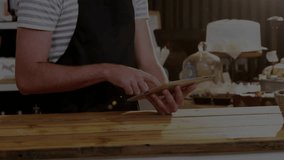 man tapping tablet and scrolling, projecting animated stock graphs over bar, guiding cafe planning. Business, technology, analytics, innovation, entrepreneurship, modern, workspace - Powered by Shutterstock - Get 15% off with code: PIKWIZARD15