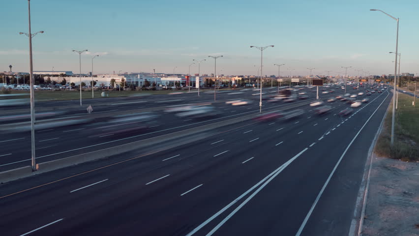 Fast cars on Highway 401 in Ontario during a clear day timelapse