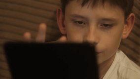 Portrait of a 12-year-old Caucasian boy using a tablet computer at home, schoolboy using a gadget in everyday life - Powered by Shutterstock - Get 15% off with code: PIKWIZARD15