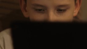 Portrait of a 12-year-old Caucasian boy using a tablet computer at home, schoolboy using a gadget in everyday life - Powered by Shutterstock - Get 15% off with code: PIKWIZARD15