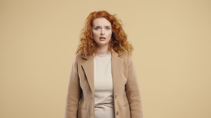 Curly Woman Reacts With Visible Fear, Startled While Looking Directly At Camera 