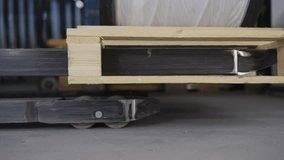 Unloading of wooden pallet being handled by metal forklift mover in an industrial setting - Powered by Shutterstock - Get 15% off with code: PIKWIZARD15