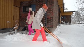 Mother and daughter shoveling snow at home during Christmas holidays. Winter tradition, festive lifestyle, outdoor activity, togetherness, bonding and seasonal joy in snowy yard. - Powered by Shutterstock - Get 15% off with code: PIKWIZARD15